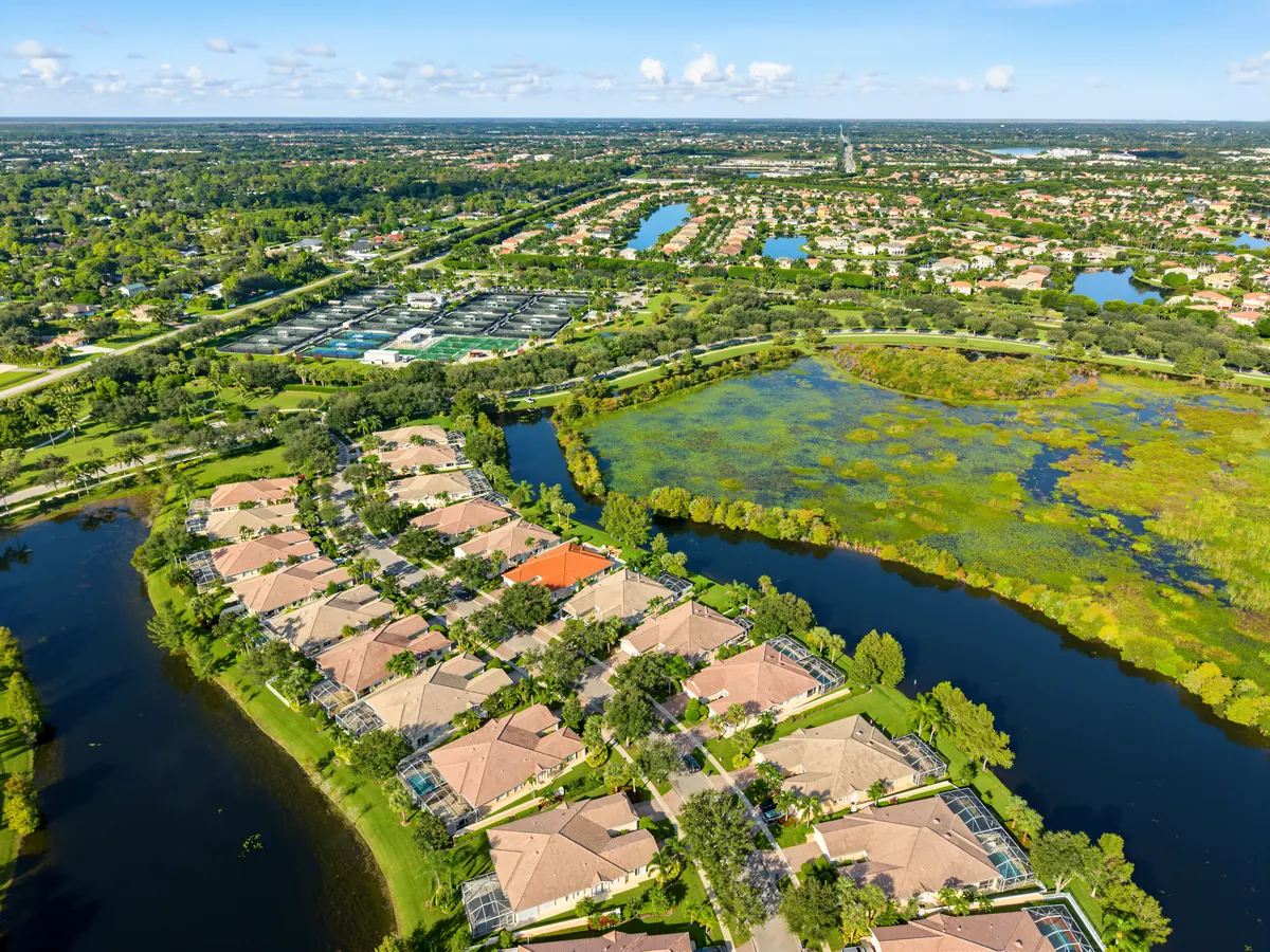 Aerial view of homes beside a lake and green wetland landscape