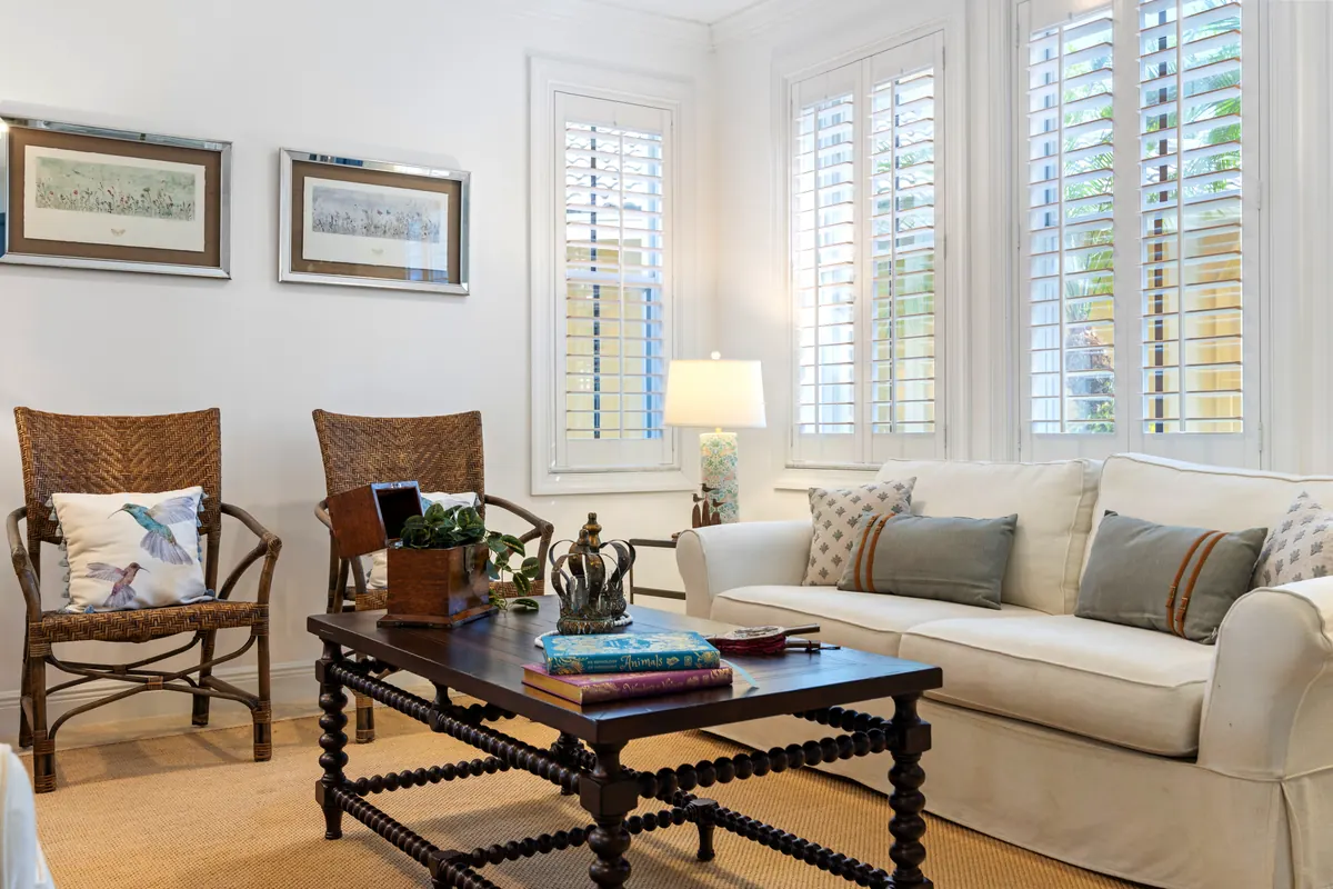 Living room with pale seating, plantation shutters and a dark coffee table
